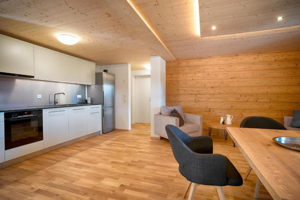uma cozinha e sala de estar com mesa e cadeiras em Tannenhof Fischbach - Fewo 6 "Karpfen" - Schluchsee, 2 Schlafzimmer, E-Auto Ladestation em Schluchsee