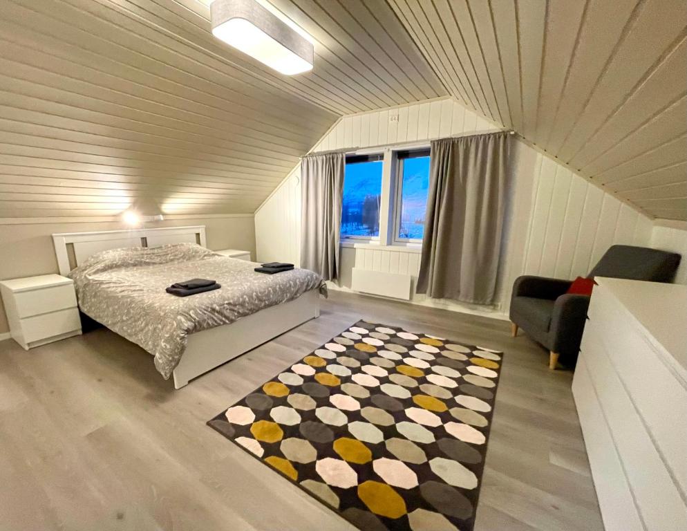 a bedroom with a bed and a window and a rug at Cozy house in an Arctic village 