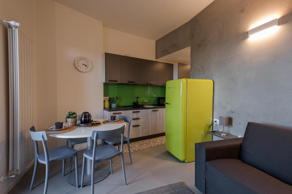 Il comprend une cuisine équipée d'une table et d'un réfrigérateur jaune. dans l'établissement B&B Maison Azzurra Malpensa, à Turbigo