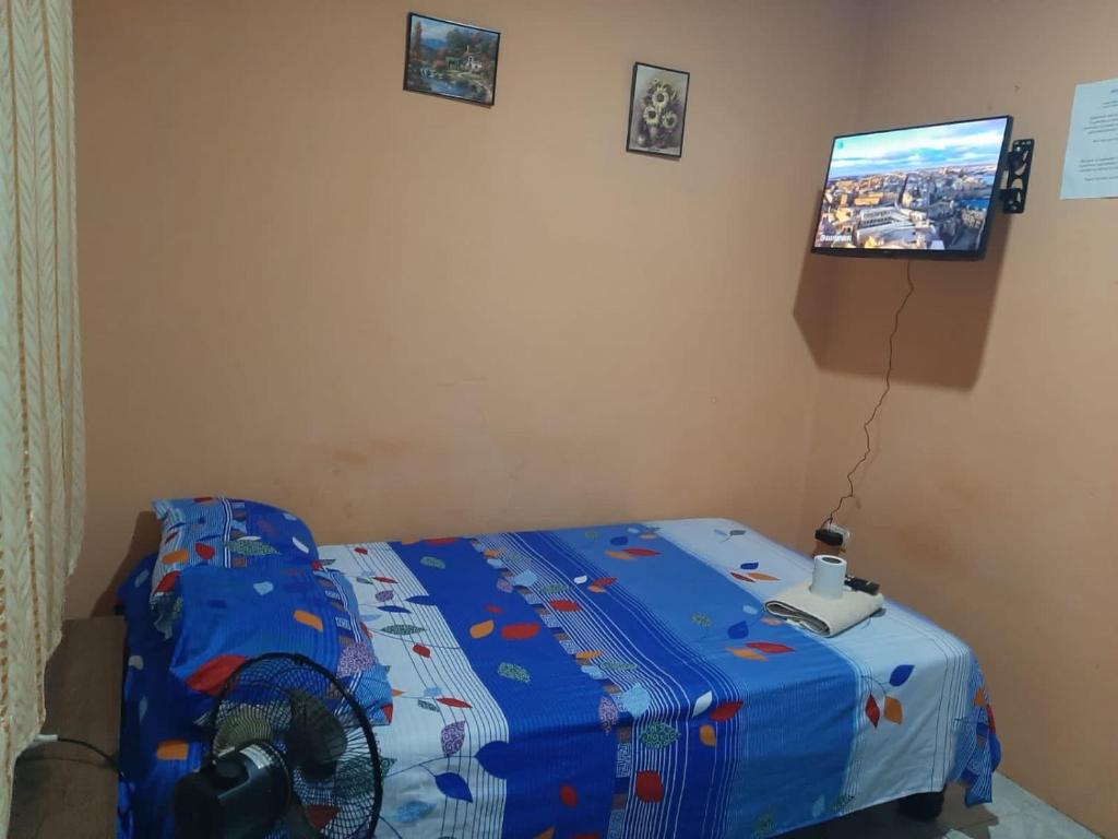 Habitación con 1 cama con ventilador y TV. en Estudio en Garzota con Cocina y lavanderia Wifi, en Guayaquil