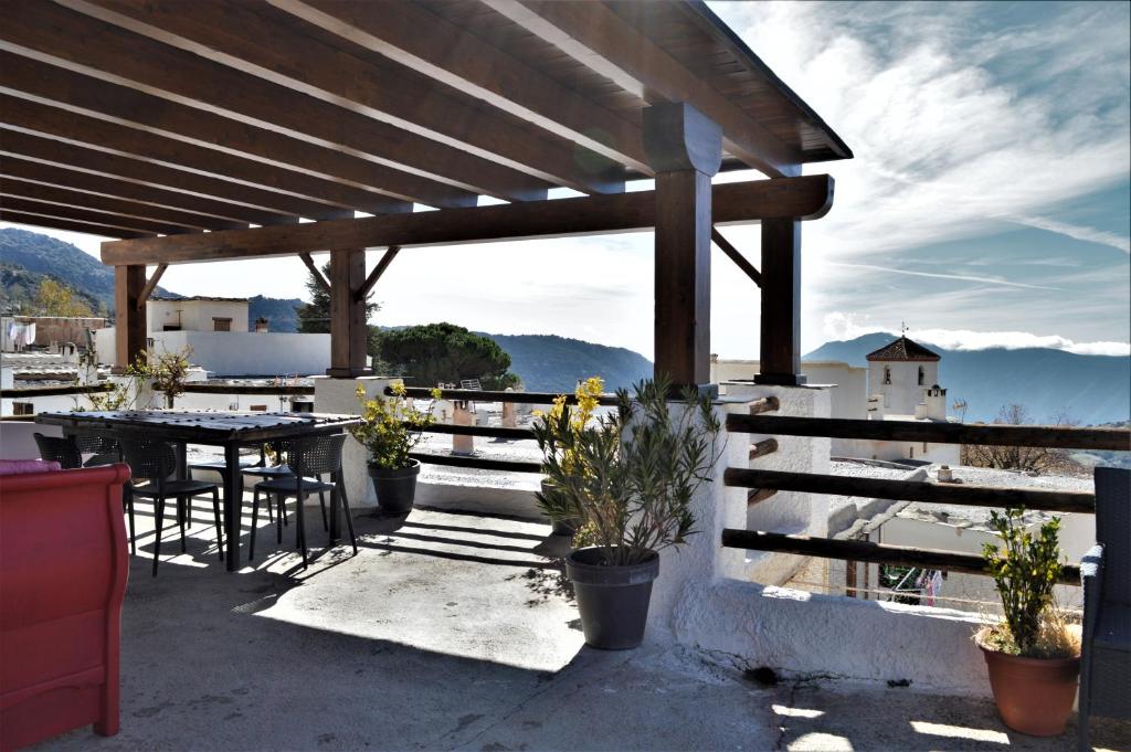 eine Terrasse mit einem Tisch und Stühlen sowie Aussicht in der Unterkunft Hotel Rural Alfajía de Antonio in Capileira