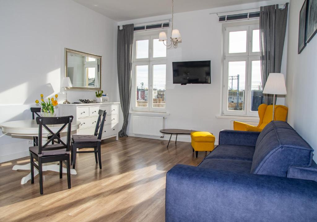 a living room with a blue couch and a table at InPoint Cracow Apartments - Near Main Market Square in Krakow
