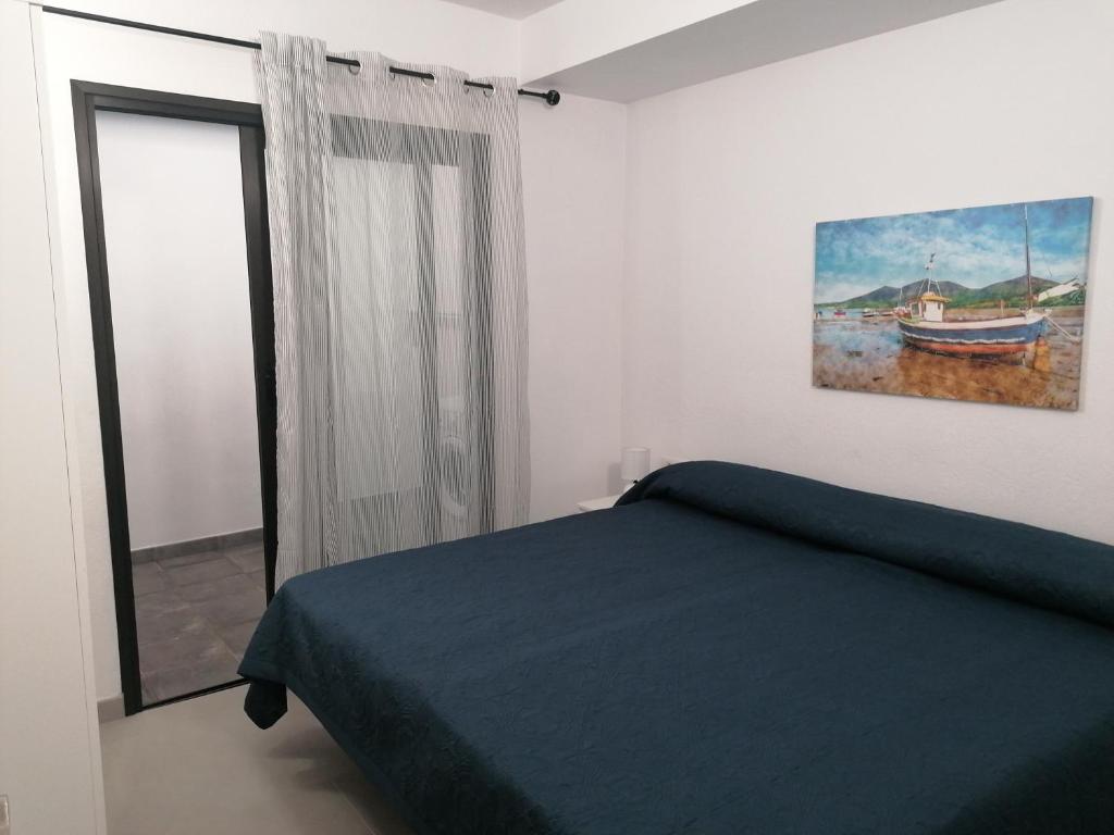 una camera da letto con un letto e un dipinto sul muro di Vivienda El Remo-Vv-3 a Los Llanos de Aridane