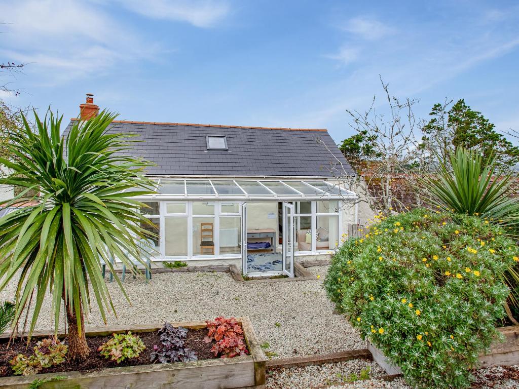 a house with a conservatory and some plants at Barn Owl - Uk44607 in Carnbrea