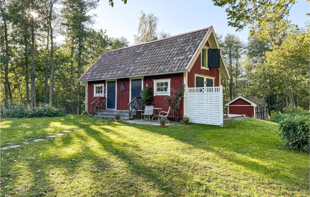 een rood huisje met een tuin bij Lovely Home In Vdd With Wifi in Väddö