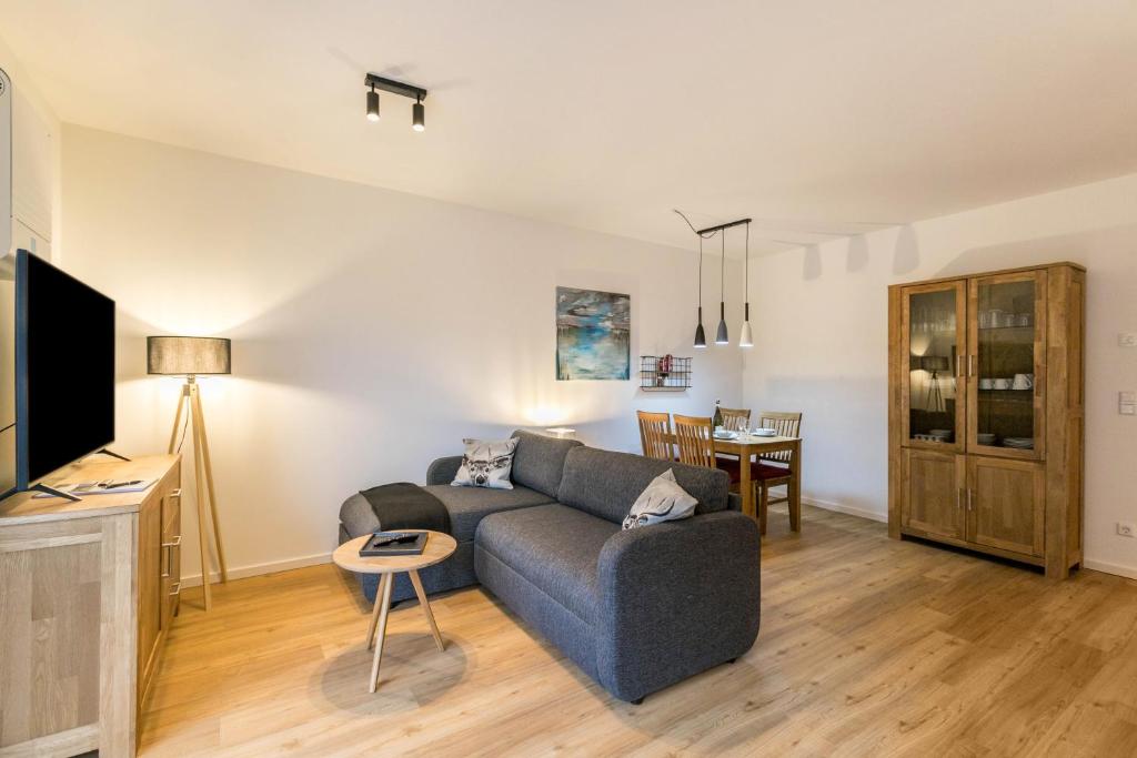 a living room with a couch and a tv at Seegaard Wohnung 3 in Husby