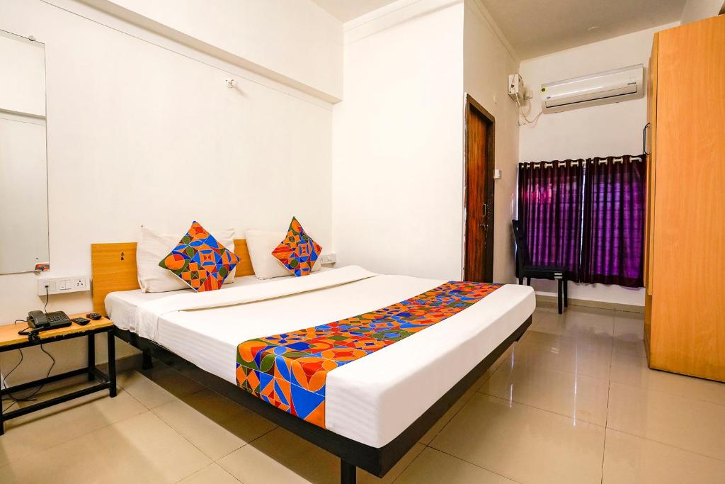 ein Schlafzimmer mit einem großen Bett in einem Zimmer in der Unterkunft FabHotel Saubhagya Elite in Nashik