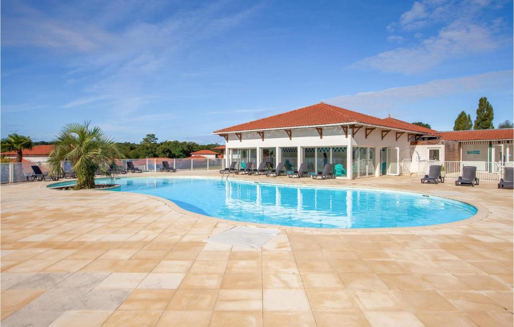 une grande piscine avec un bâtiment en arrière-plan dans l'établissement Lovely Apartment In Cassen With Outdoor Swimming Pool, à Cassen
