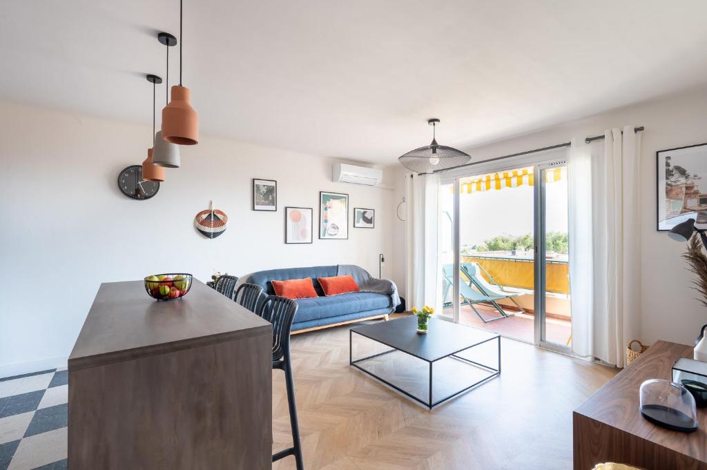 ein Wohnzimmer mit einem Sofa und einem Tisch in der Unterkunft * Le Floréal * Magnifique T3 vue Mer in Bandol