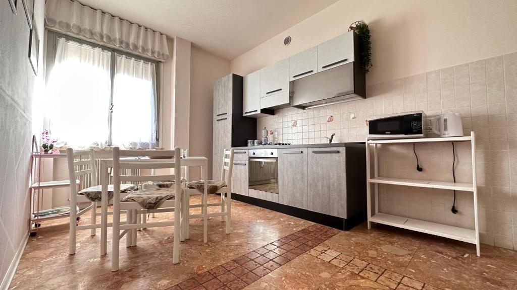 a kitchen with white appliances and a table and chairs at Casa TOÈ in Conegliano