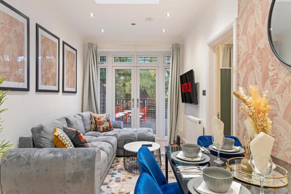 uma sala de estar com um sofá cinzento e cadeiras azuis em Gorgeous 3-bedroom in London - Sleeps 8 em Londres