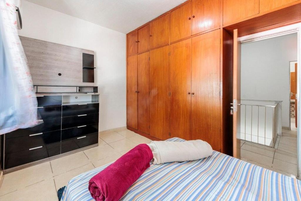 1 dormitorio con 1 cama y armario de madera en Casa Branca 355 Familiar en Río de Janeiro