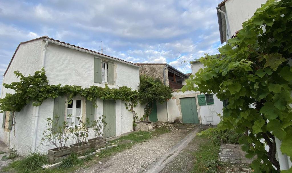 une vieille maison blanche avec une porte verte dans l'établissement Charmante maison de village typique rhétaise, à La Couarde-sur-Mer