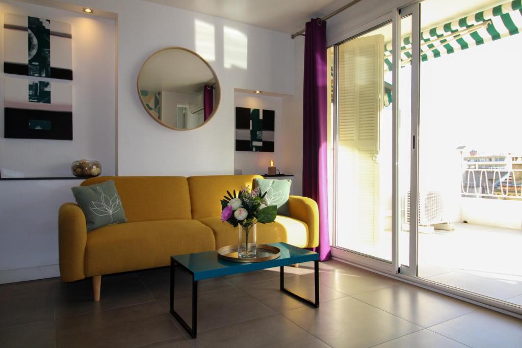 ein Wohnzimmer mit einem gelben Sofa und einem Tisch in der Unterkunft Le Bobillot By ApiRent #Central #Terrasse #Wifi #Clim in Cannes