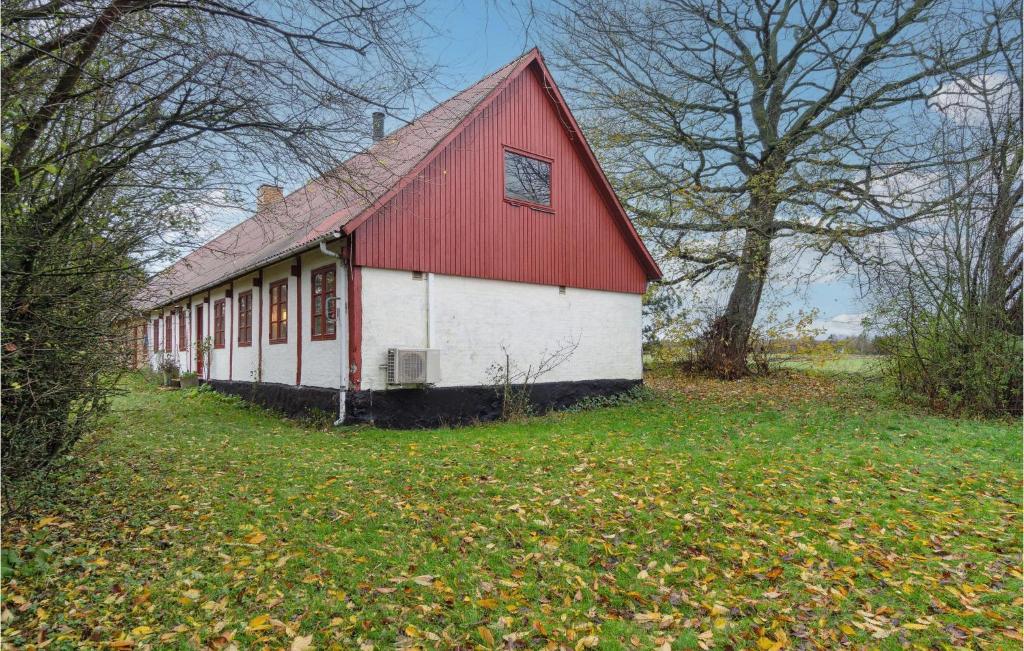 Czerwono-biała stodoła siedząca na polu w obiekcie 3 Bedroom Lovely Home In stermarie w mieście Østermarie
