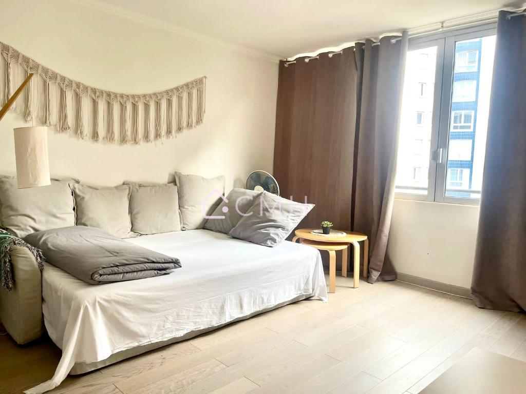 a bedroom with a white bed and a window at Modern Porte de Versailles Flat - Expo Next Door in Vanves