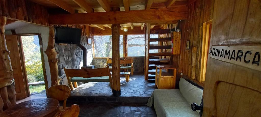 a living room with a couch and a tv in a cabin at Tres Continentes in San José de Maipo