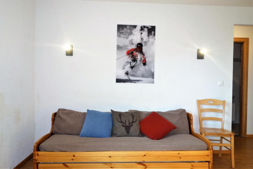 een bank in een woonkamer met een foto aan de muur bij Pracondu RENOVE OUTDOOR & FUN Appartement 8 personnes in Nendaz