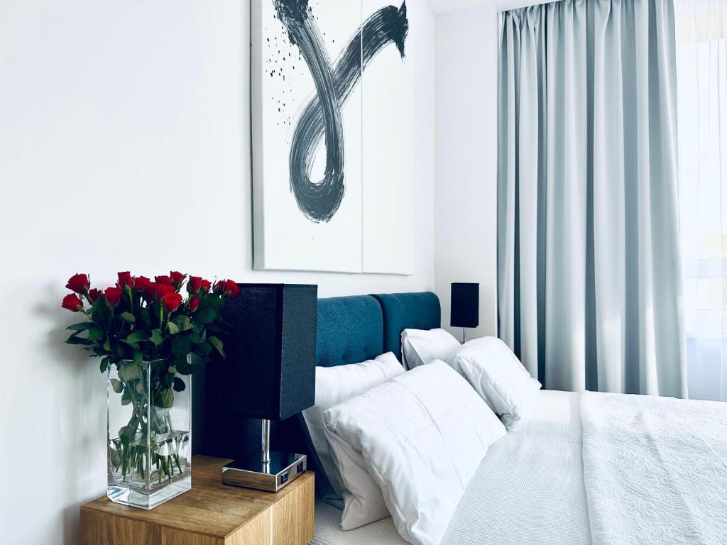 a living room with a bed and a vase of flowers at BEBA SIGNATURE apartment in Košice