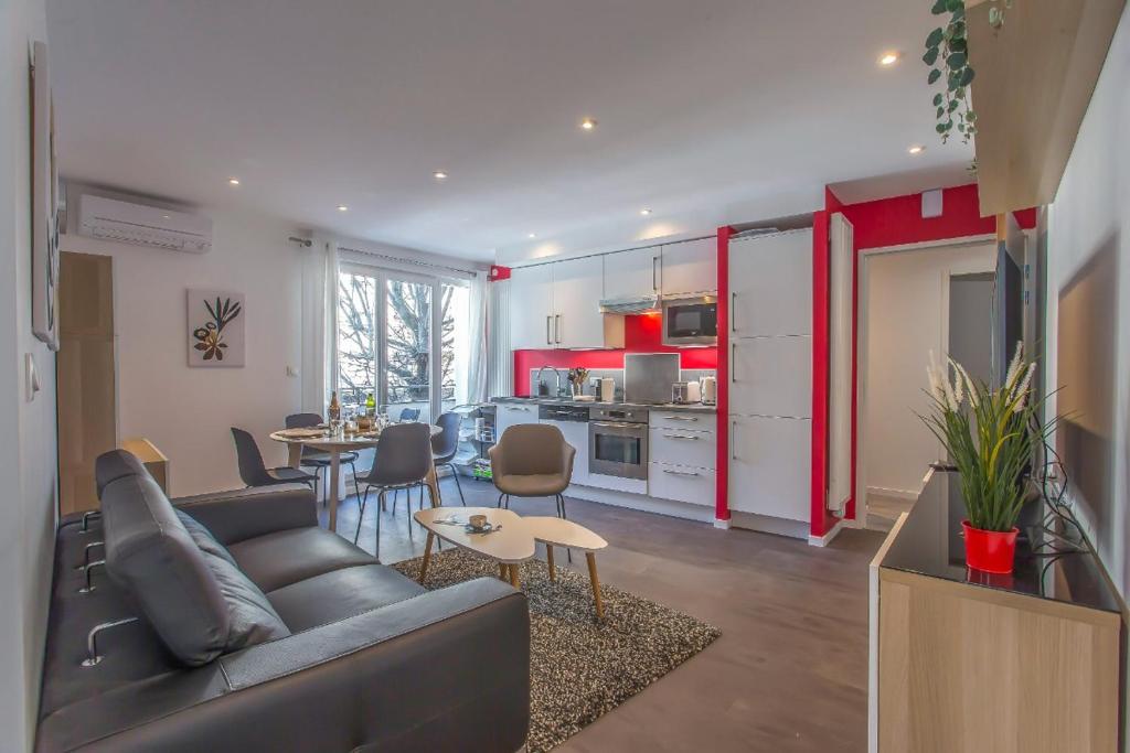 ein Wohnzimmer mit einem Sofa und einem Tisch sowie eine Küche in der Unterkunft Alberts Cocooning in Grenoble