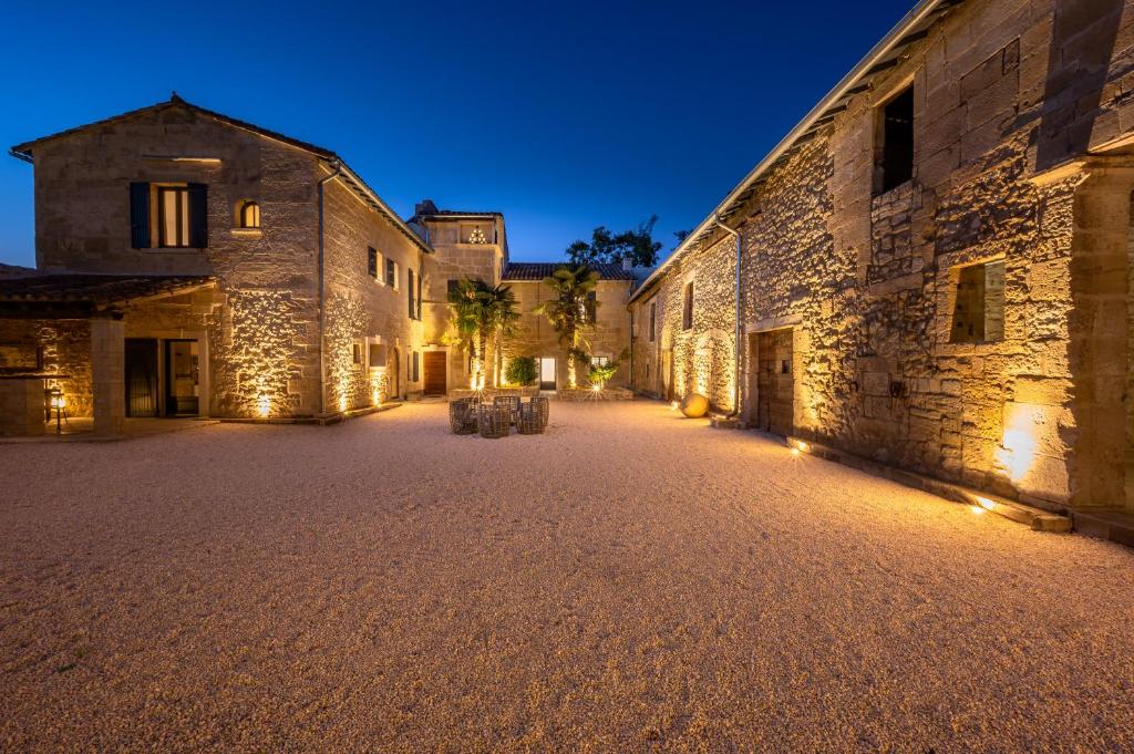 une cour vide d'un vieux bâtiment en pierre la nuit dans l'établissement Mas provençal avec piscine chauffée !, à Tarascon