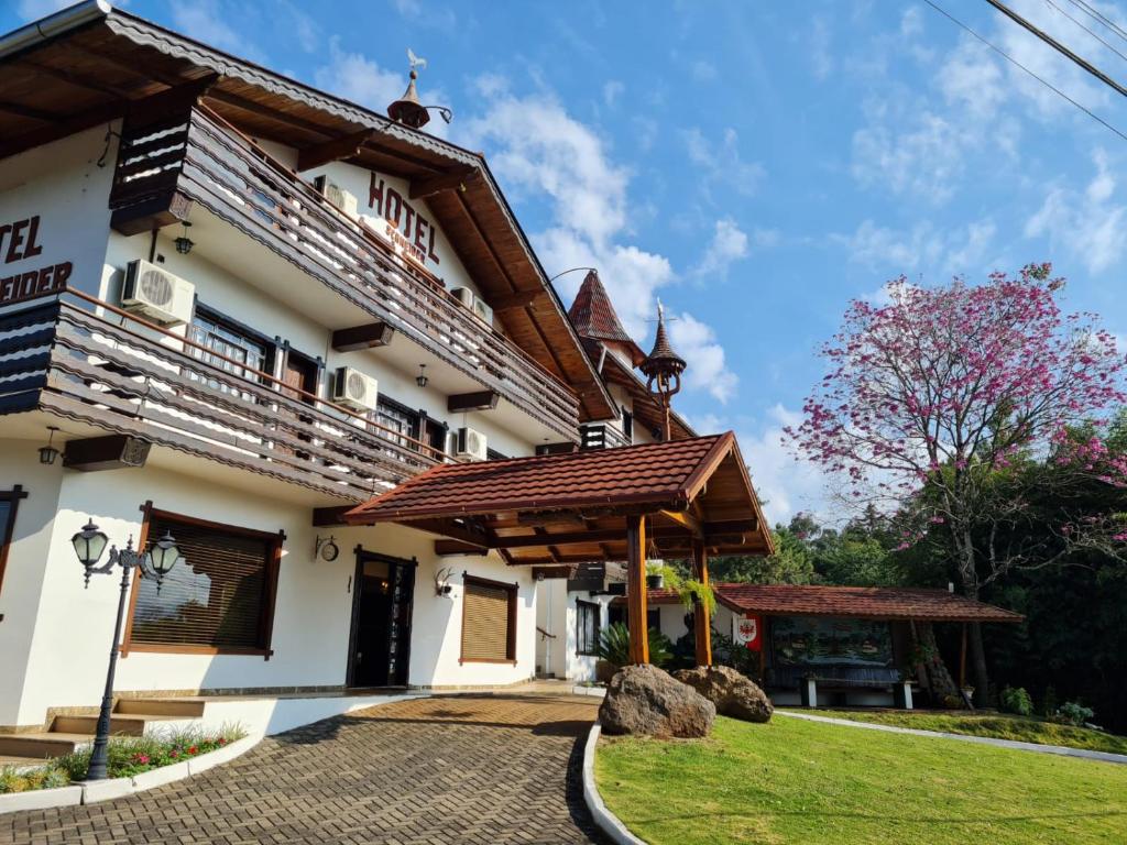 a house with a wooden roof at Hotel Schneider in Treze Tílias