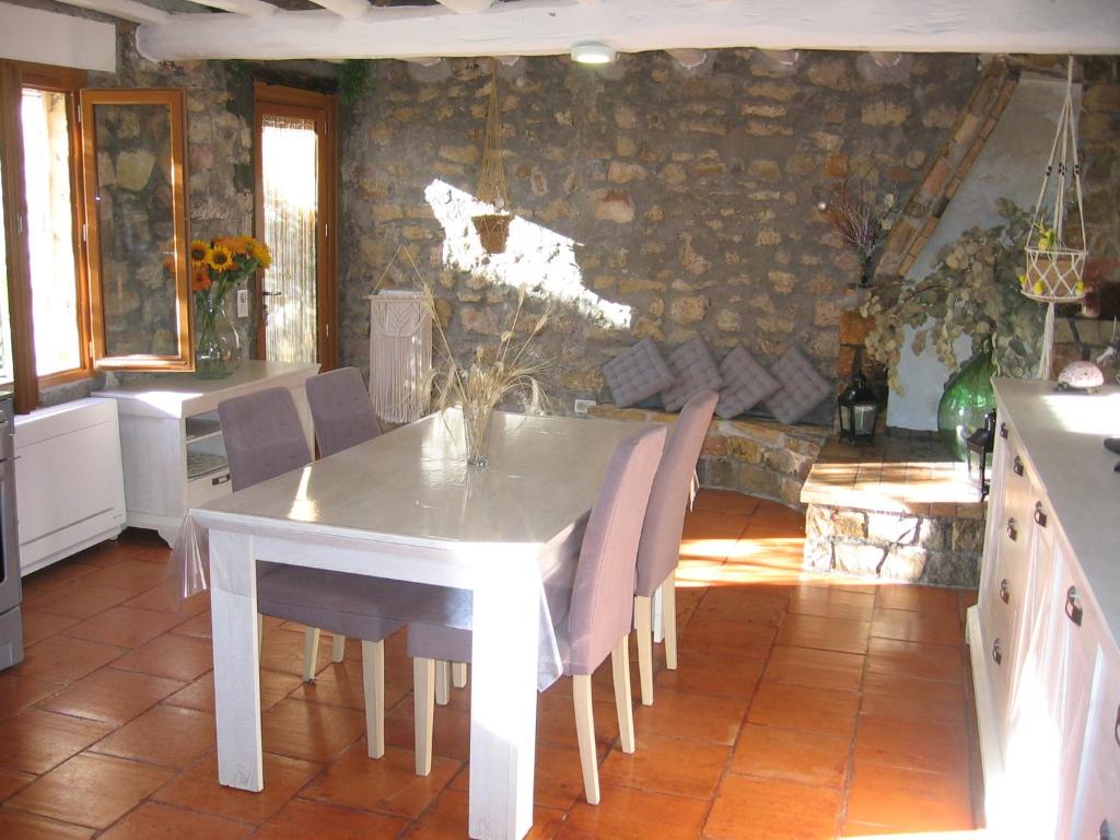 a dining room with a white table and chairs at Les Genêts in Fayence