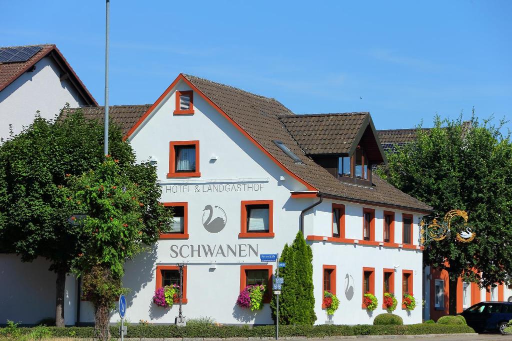 Ein weißes Gebäude mit einem Schild drauf. in der Unterkunft Hotel Schwanen in Kehl am Rhein
