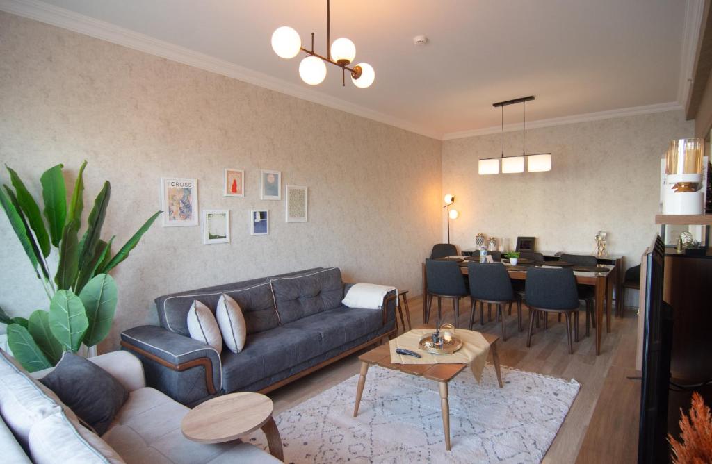 a living room with a couch and a dining room at Charming 3bdr Apt In The Heart Of Halkal Merkez in Istanbul