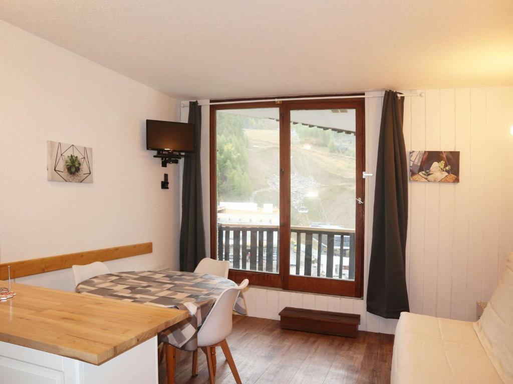 une salle à manger avec une table et une fenêtre dans l'établissement Studio 4 pers skis aux pieds, balcon sud - FR-1-322-129, aux Orres