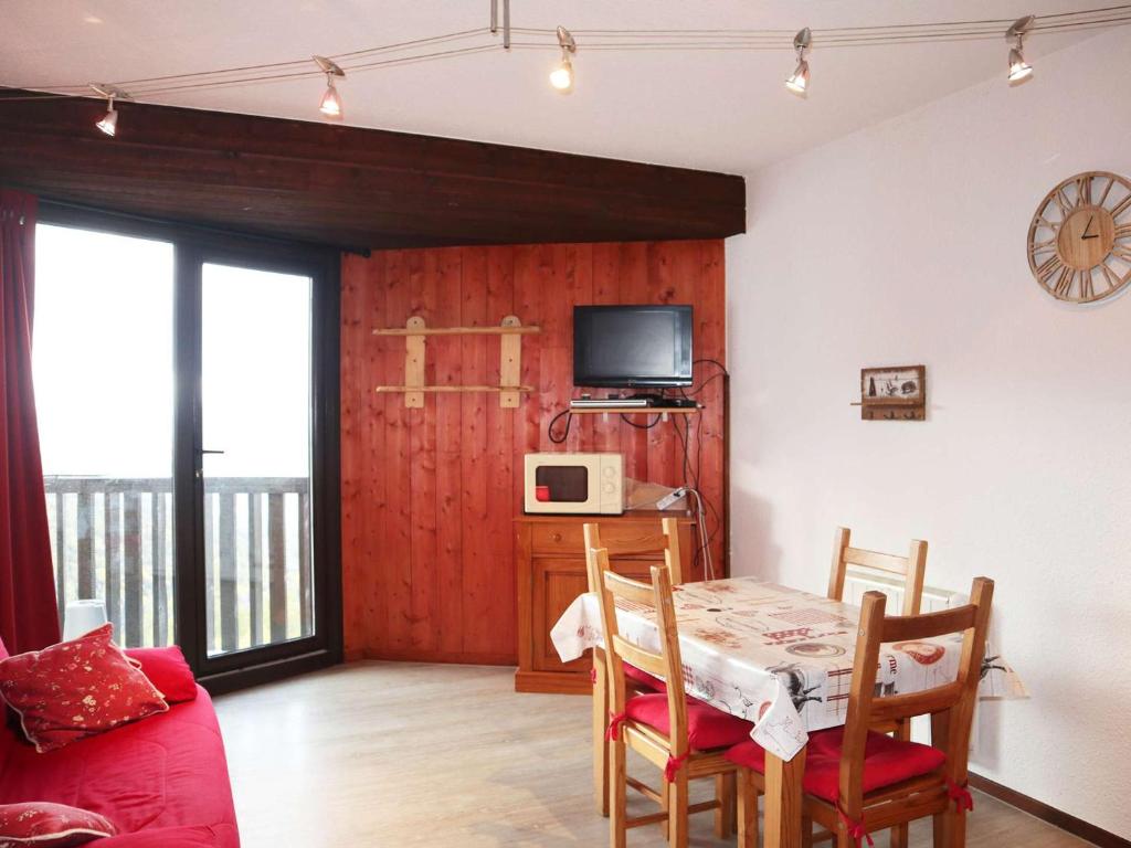 une salle à manger avec une table et une télévision dans l'établissement Studio aux Orres, skis aux pieds, pour 4 personnes - FR-1-322-138, aux Orres