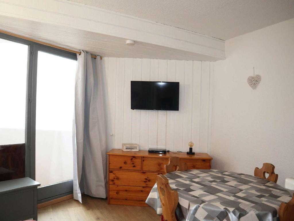 a bedroom with a bed and a television on the wall at Studio Les Orres, 1 pièce, 4 personnes - FR-1-322-263 in Les Orres