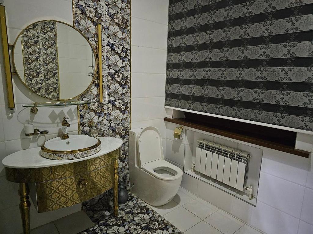 a bathroom with a toilet and a sink and a mirror at Elite Hotel in Tashkent