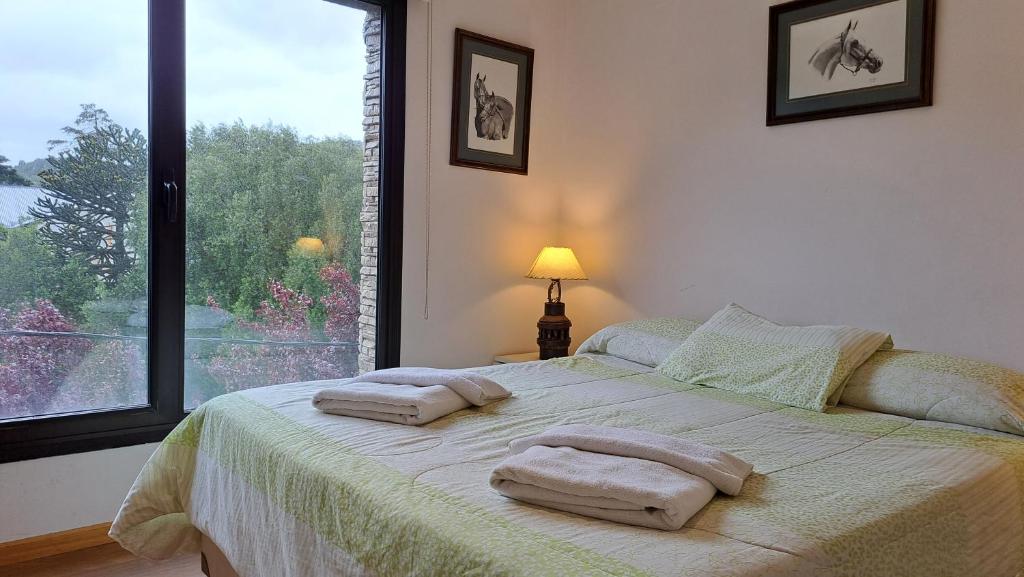 een slaapkamer met een bed met twee handdoeken erop bij La Esquina in San Martín de los Andes