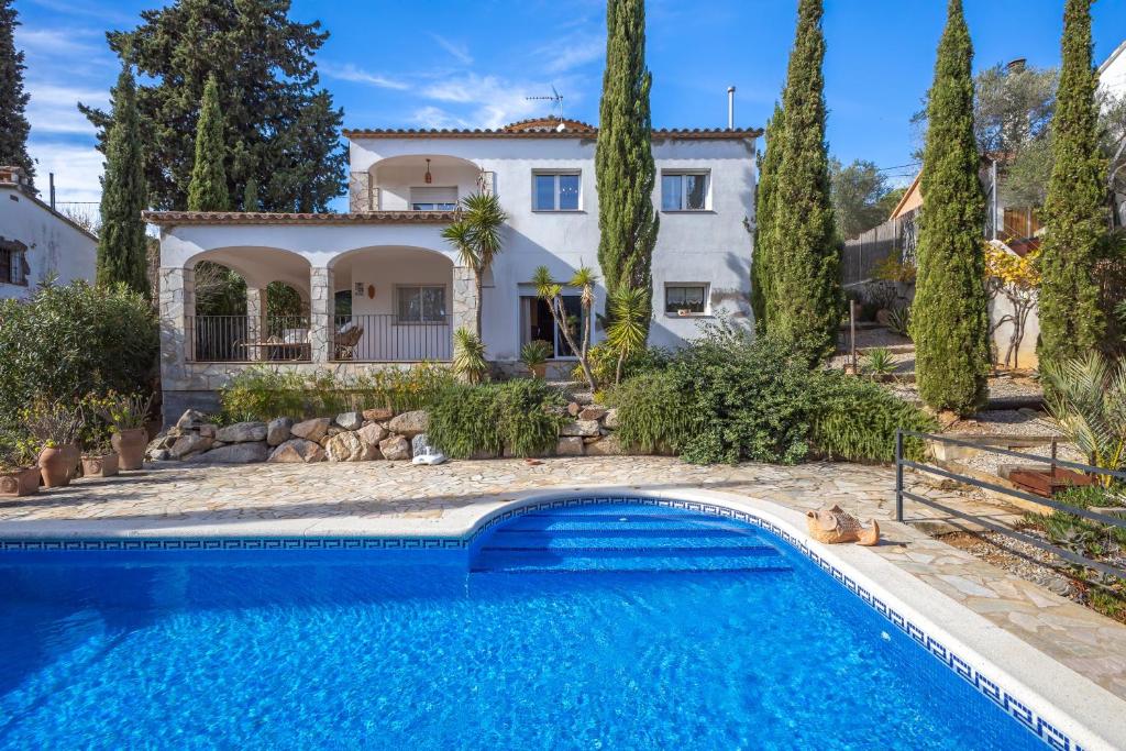 a villa with a swimming pool in front of a house at Villa Dolly in Calonge
