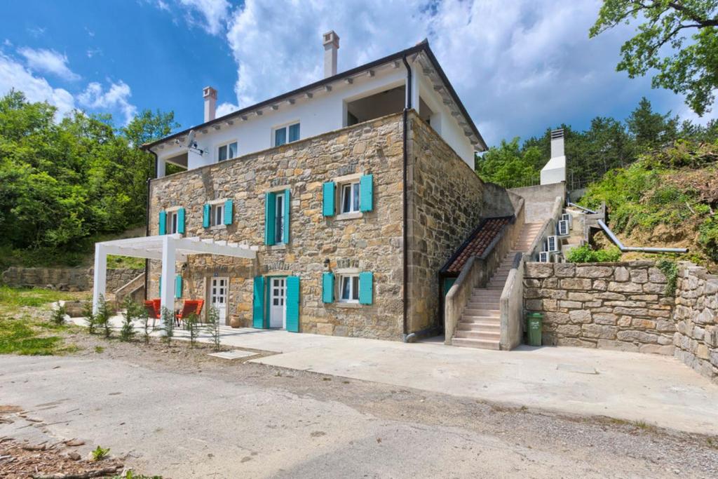 uma casa de pedra com janelas azuis e uma parede de pedra em Villa Lapis - Happy Rentals em Buzet