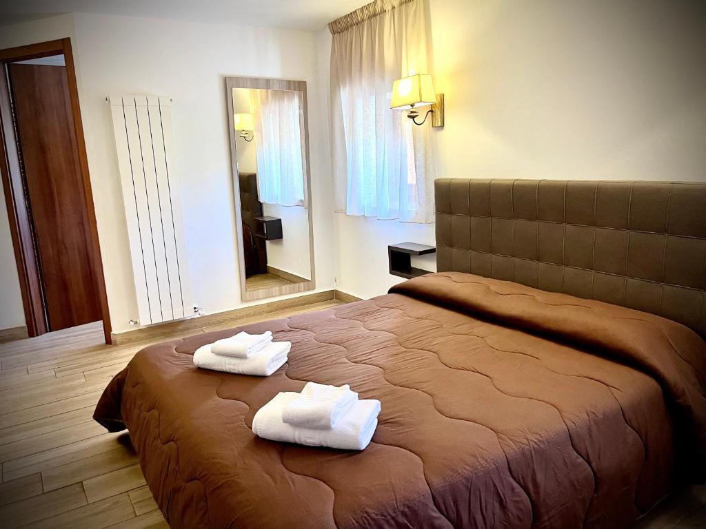 une chambre d'hôtel avec un lit et des serviettes. dans l'établissement Hotel Pinguino, à Pescasseroli