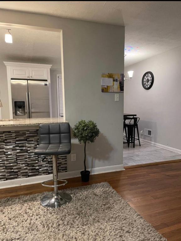 a living room with a chair and a kitchen at Amir Travels in Atlanta