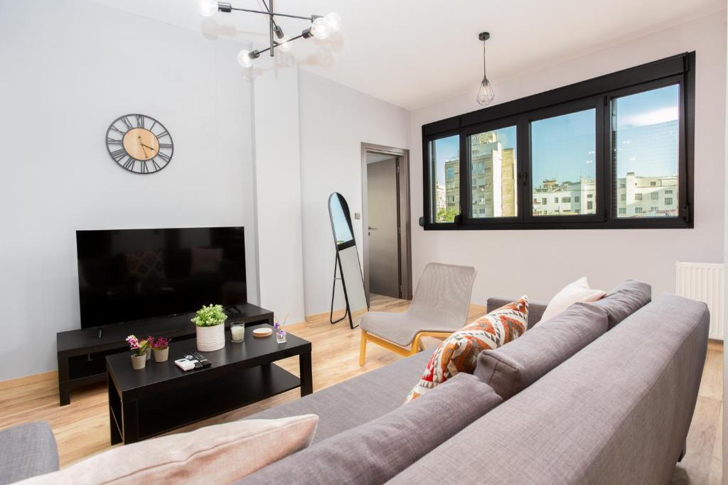 a living room with a couch and a tv at Jim & Jo House in Thessaloniki