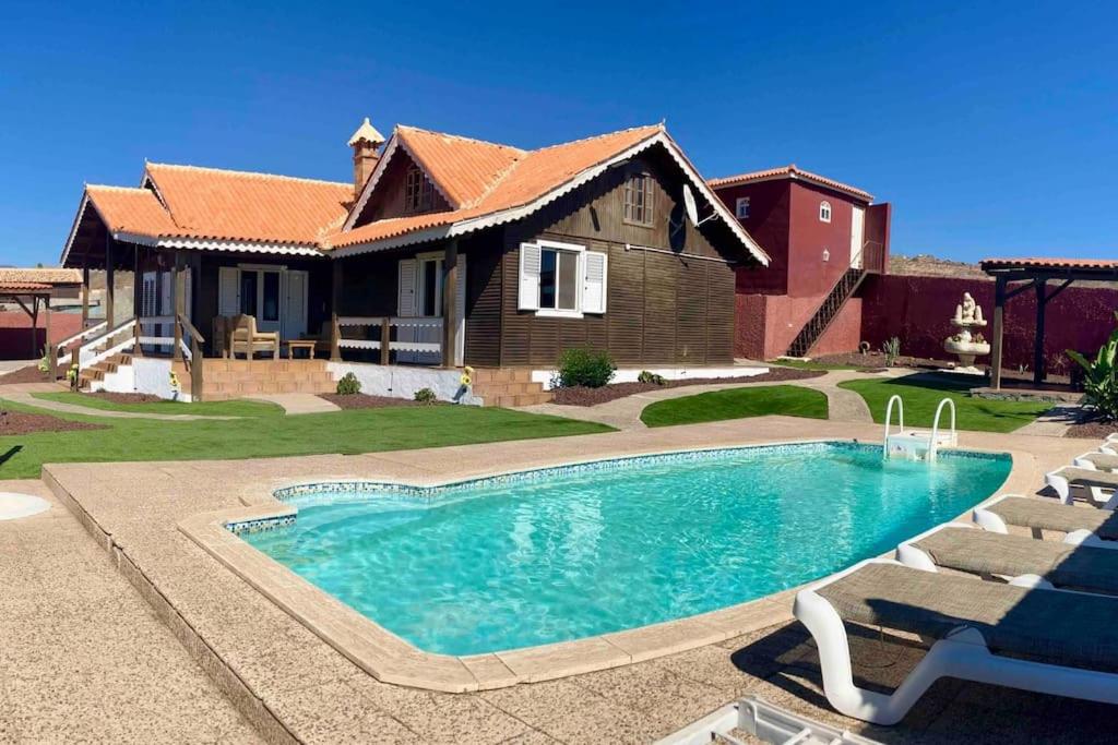 a house with a swimming pool in front of a house at Casa Inmaculada in Maspalomas