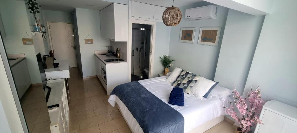 a small bedroom with a bed and a kitchen at Beach House Apartment, Playa Malagueta in Málaga