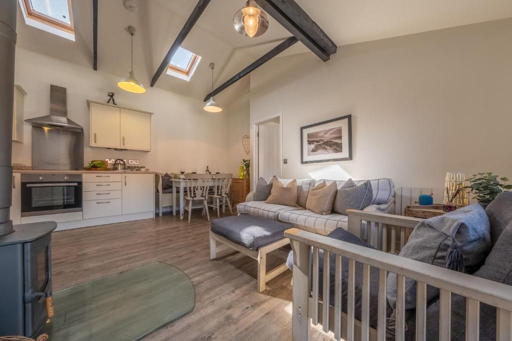ein Wohnzimmer mit einem Sofa und einer Küche in der Unterkunft Duffields Cottage in Brancaster