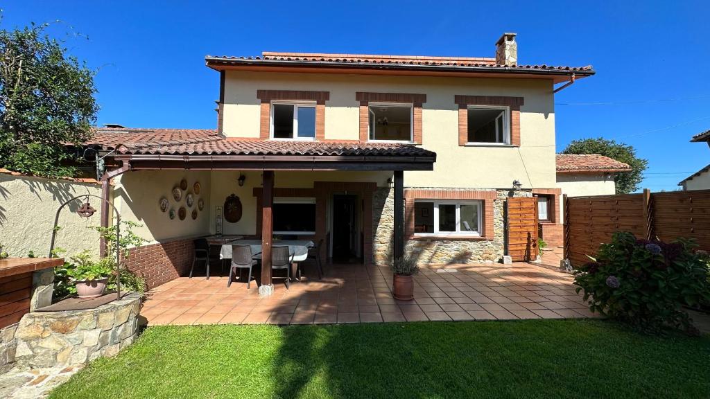 ein Haus mit einer Terrasse mit einem Tisch im Hof in der Unterkunft Casa Rural La Quinta del Taraceo in Muros de Nalón