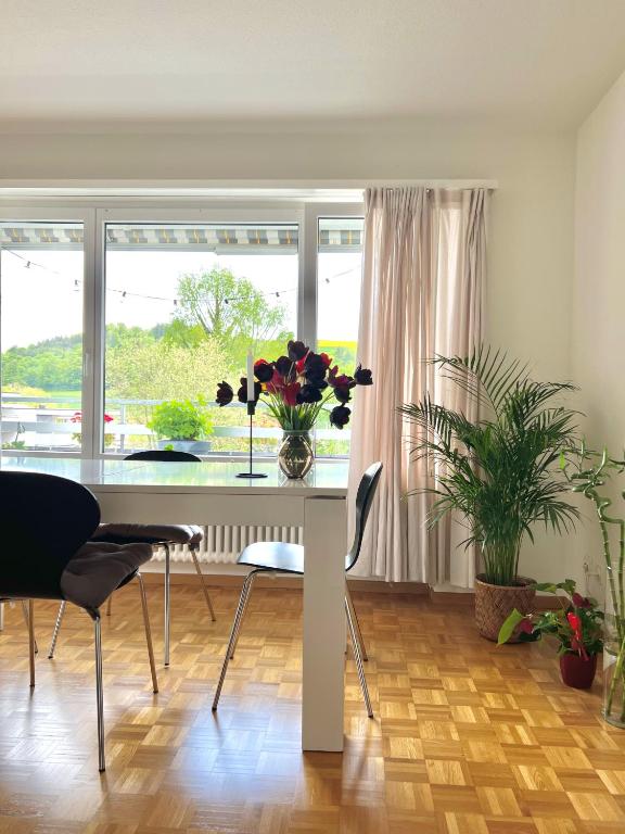 uma sala de jantar com uma mesa com flores em Appartamento per 4 persone em Rudolfstetten