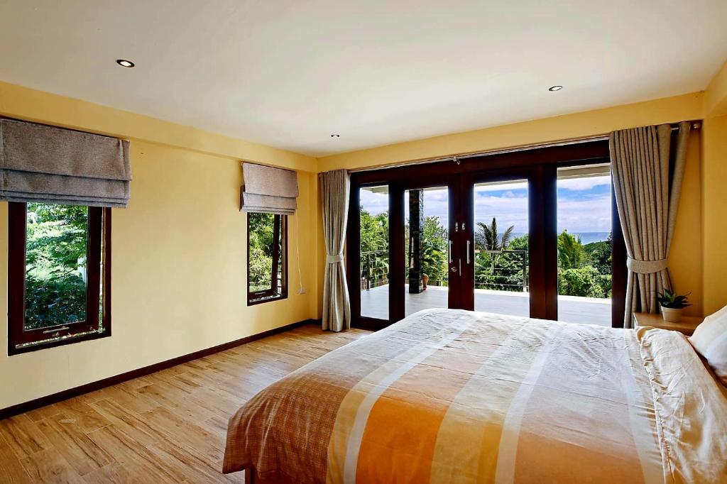 um quarto com uma cama grande e janelas grandes em Dream view "The Balcony & Terrace Garden" em Ko Phangan