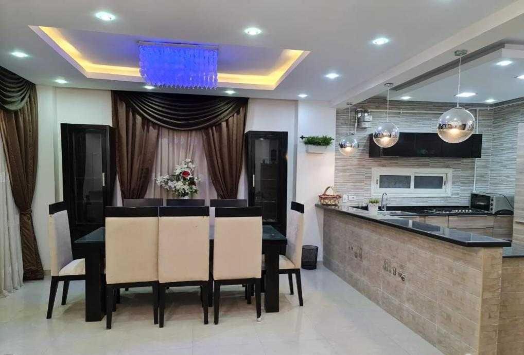 a dining room with a table and a kitchen at Appartements de luxe à Al Mahdi in Dakhla