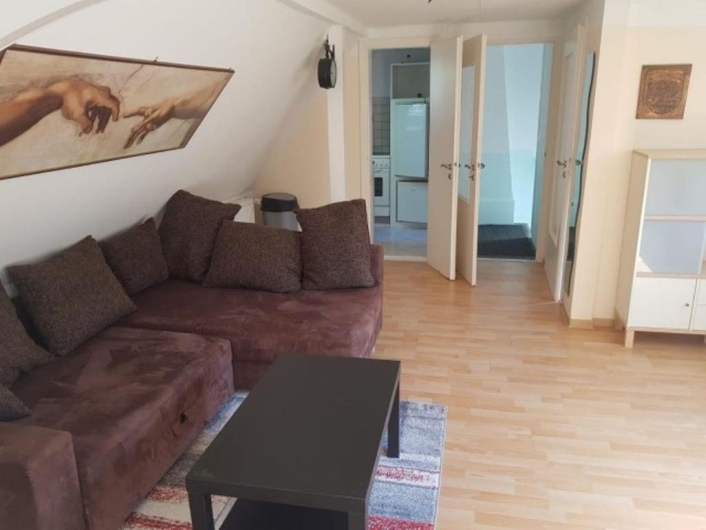 een woonkamer met een bruine bank en een tafel bij Haus Mara in Emden