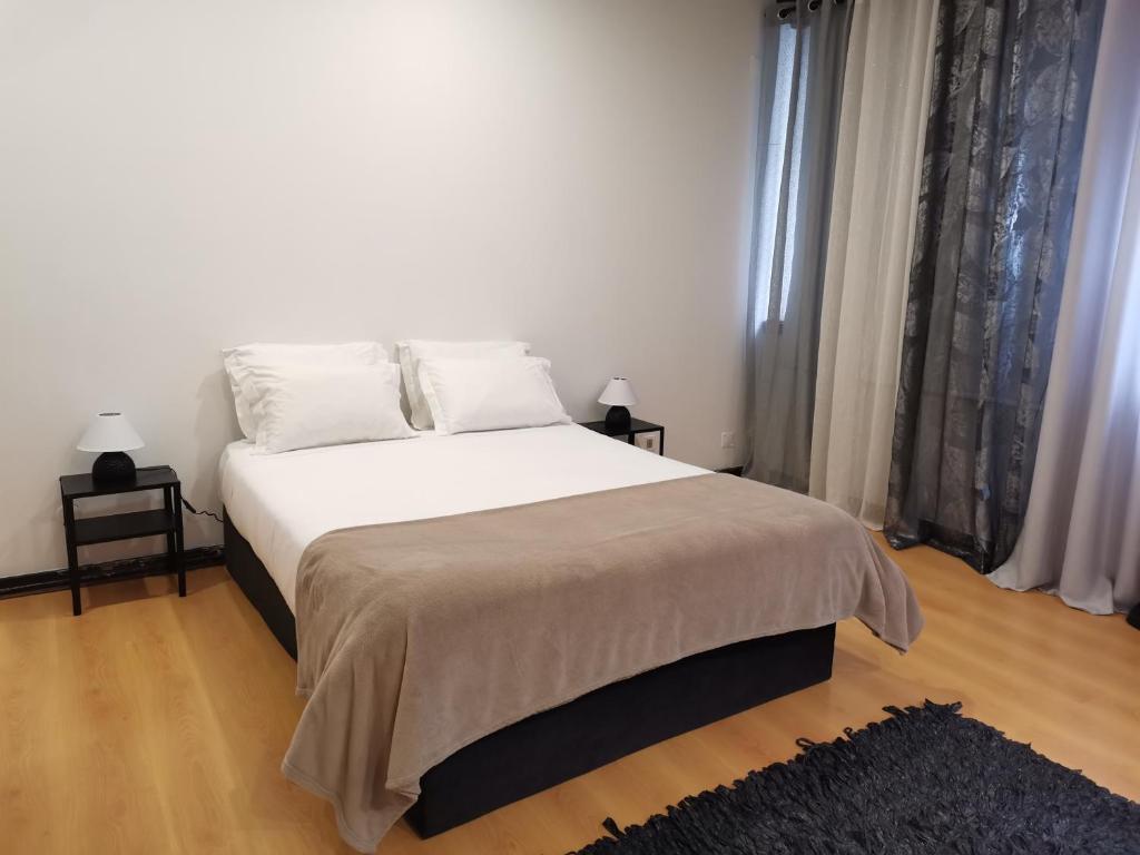 a bedroom with a large bed with white sheets and pillows at Espaço_Zero[Downtown] 01 in Porto