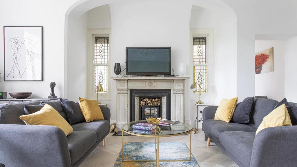 a living room with two couches and a fireplace at Stunning 4-Bed Property in London-Parking & Garden in London