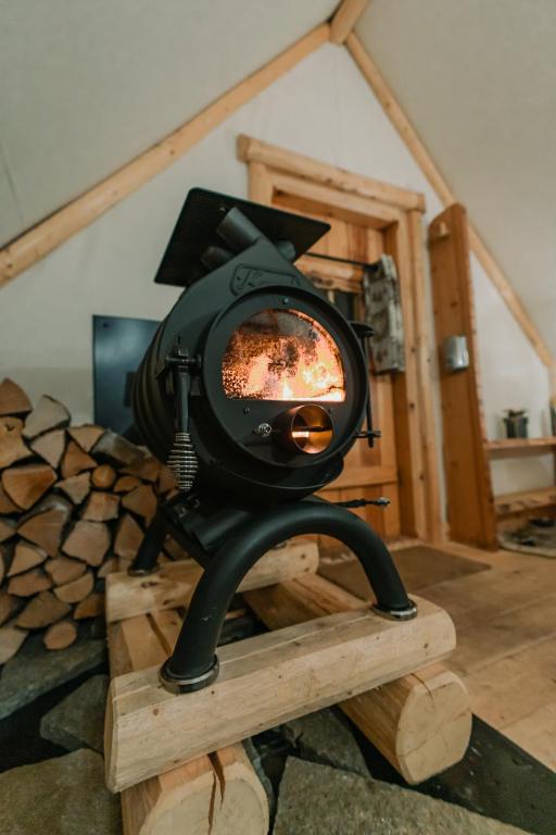 a stove sitting on a wooden stand in a room at Altipik - Lodges Insolites in Mont-Saxonnex